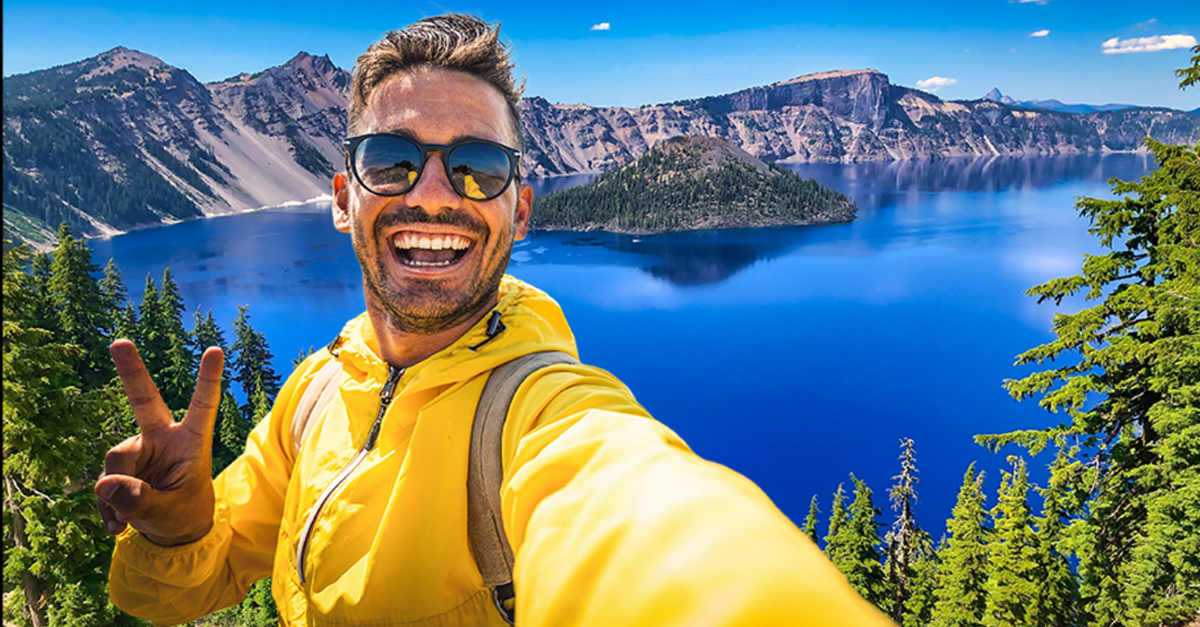 Man in yellow jacket taking a selfie, Crater Lake National Park