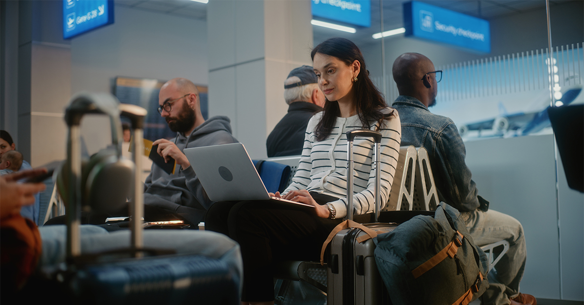Crowded International Airport Terminal: Adult Woman Working on Laptop, Having Online Video Call. Diverse People Sitting in Departure Lounge of Airline Hub, Waiting for Flight, Using Digital Devices.