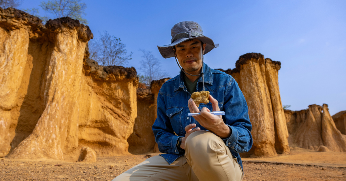 Asian geologist is exploring and surveying the sample rock