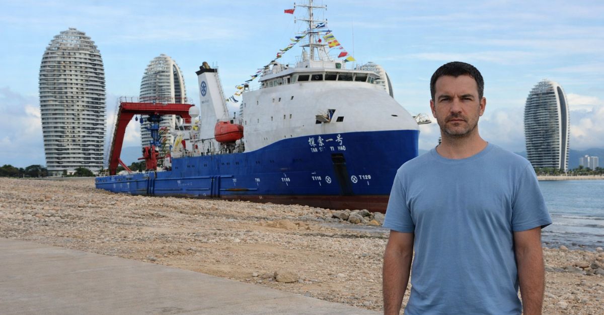 Man standing near the Tansuo-1 ship