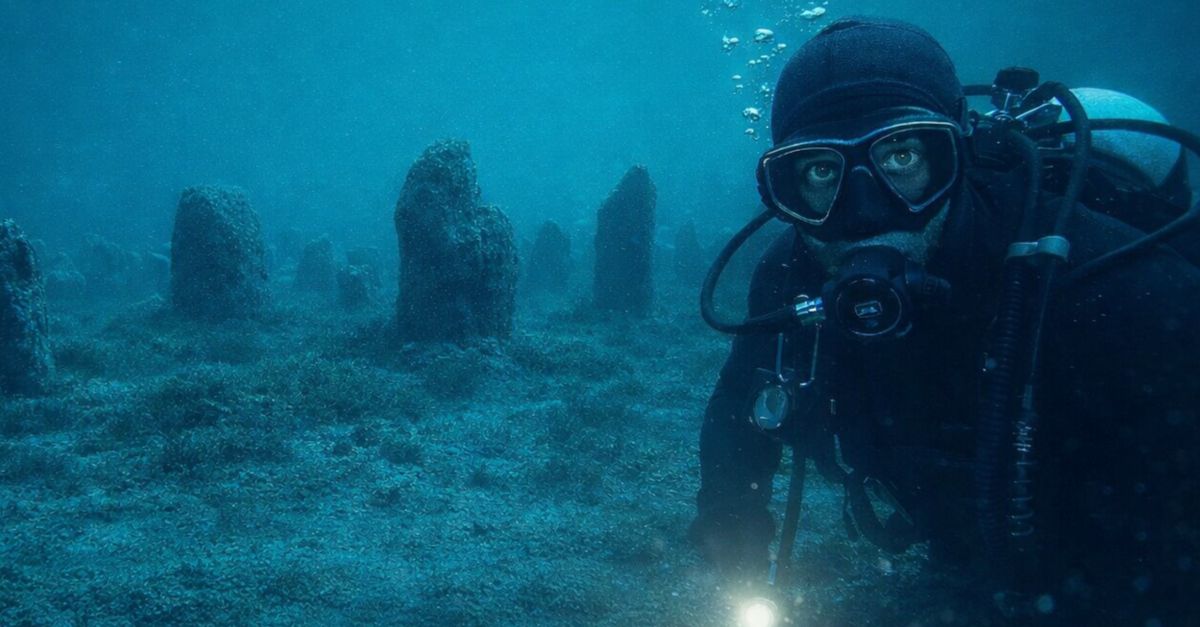 Diver exploring ancient stones beneath the sea
