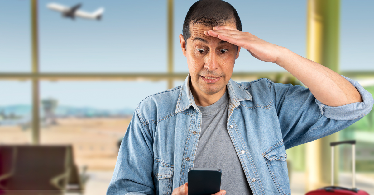 Man texting using smartphone at airport stressed