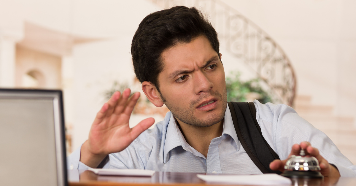 Angry and tired guest touching the bell of the recepcionist