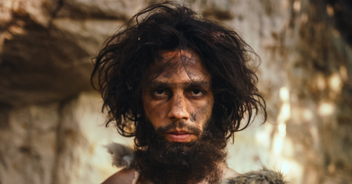 Portrait of Primeval Caveman Wearing Animal Skin Holding Stone