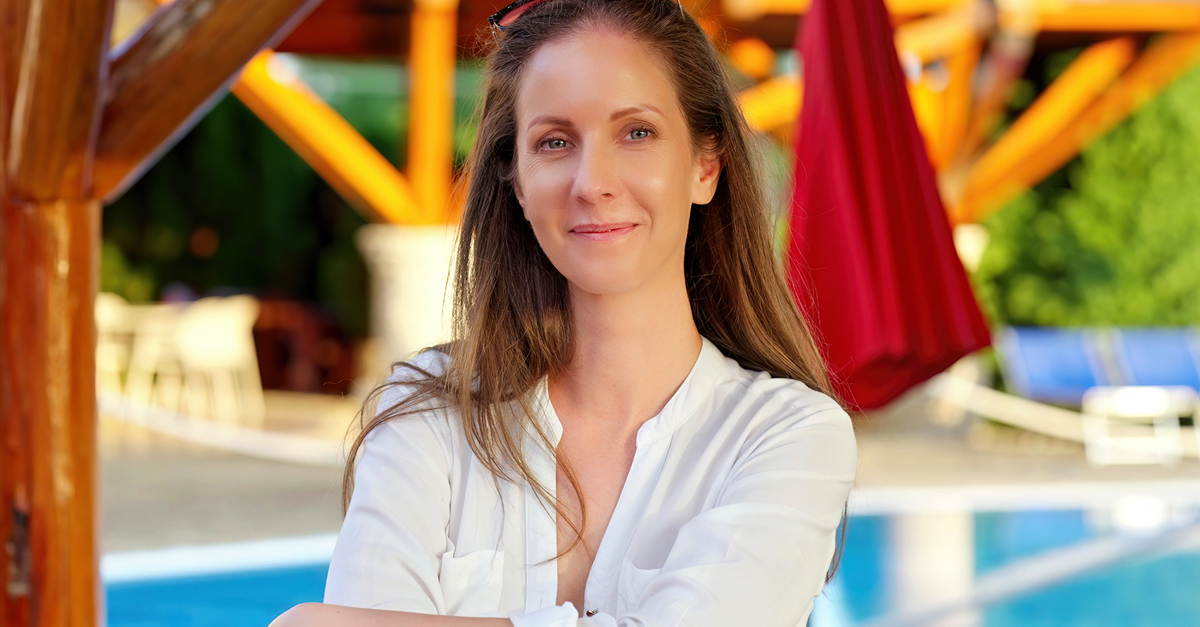 Portrait of happy satisfied woman in hotel garden on vacation, smiling. Poolside at home in summer morning.
