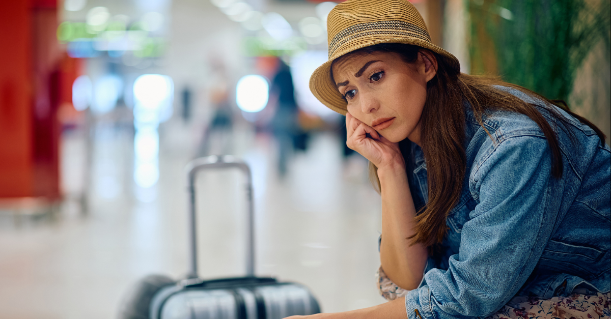 Distraught female passenger waiting at departure area.