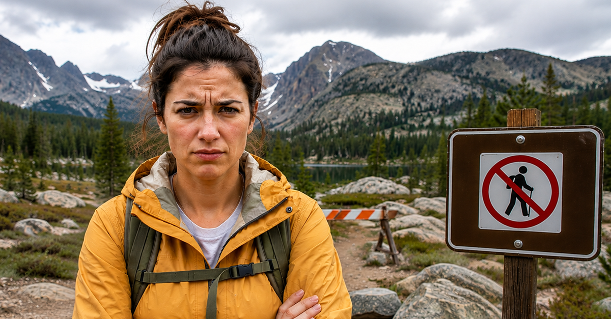 Woman in yellow jacket standing next to closed trail