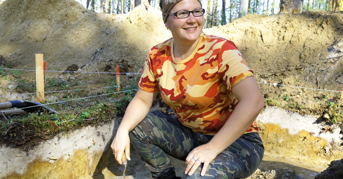 The girl-archaeologist with a trowel in his hand in the excavation