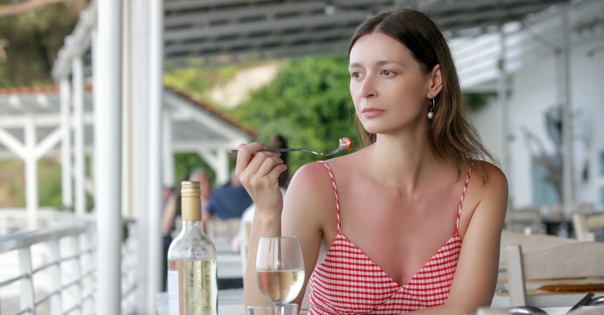 Young woman eating alone in the restaurant. Concept of solo dining in a casual restaurant. Eating out alone