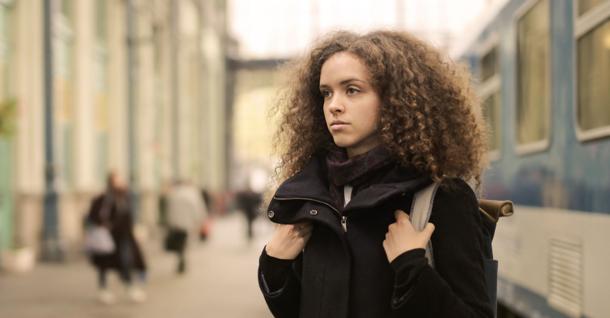 woman-in-black-coat-standing-standing-beside-subway
