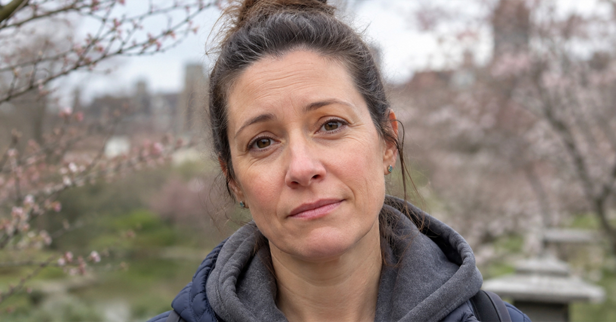 Woman with a bun, surrounded by cherry blossom trees.