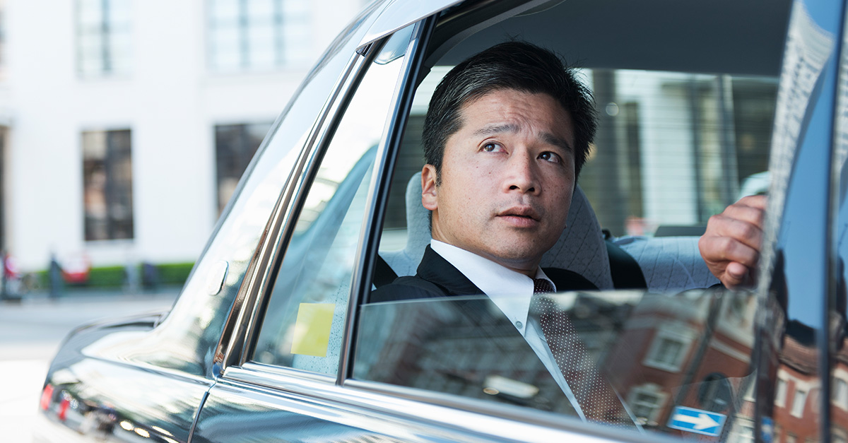 Middle-aged Japanese businessman looking out from a taxi window