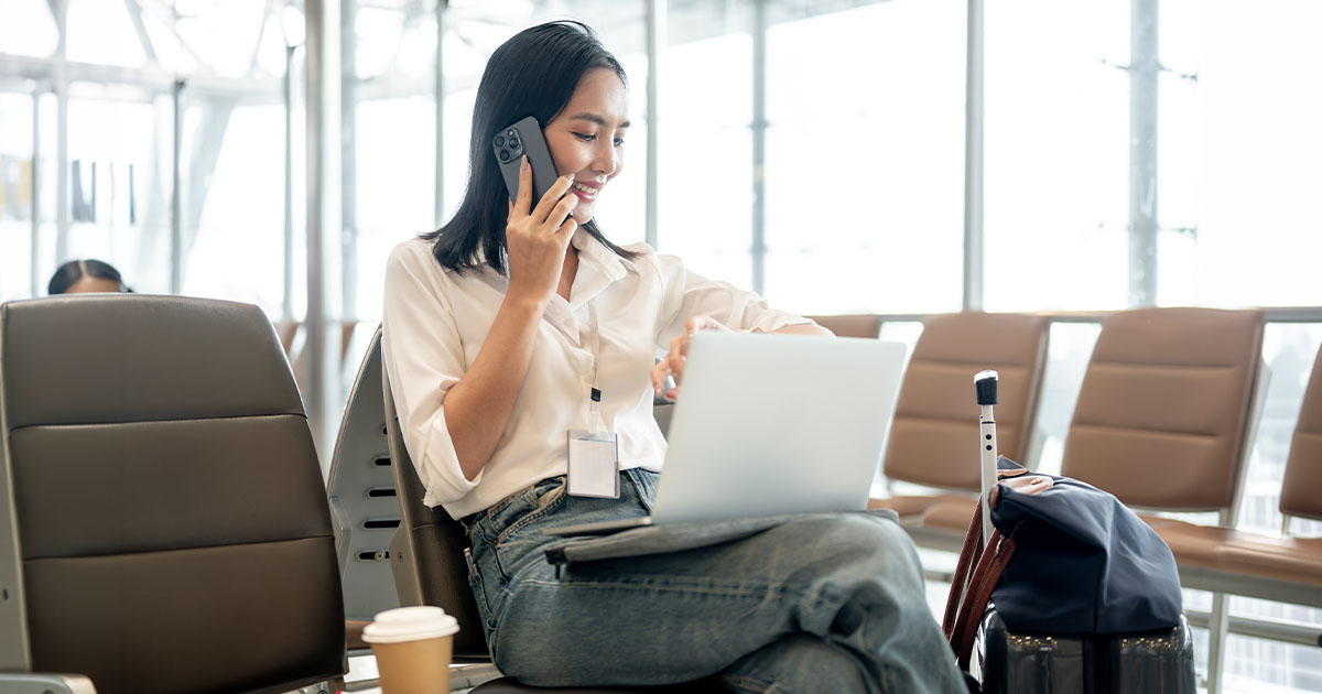 Woman working on laptop in airport