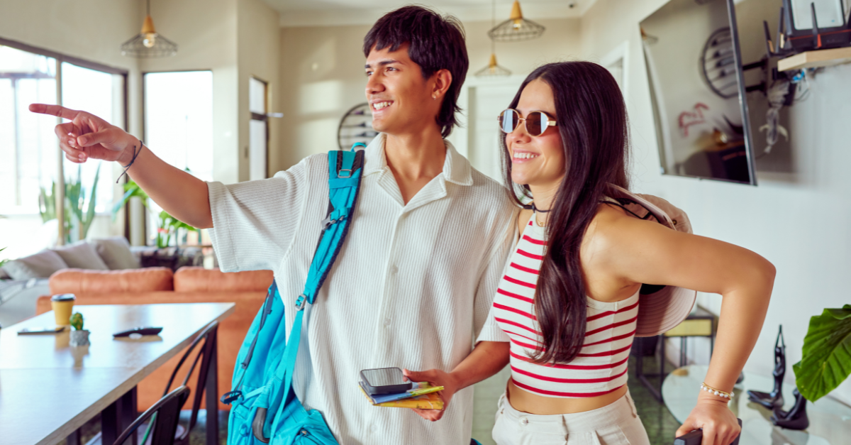 Young latin American couple arriving at small hotel for vacation